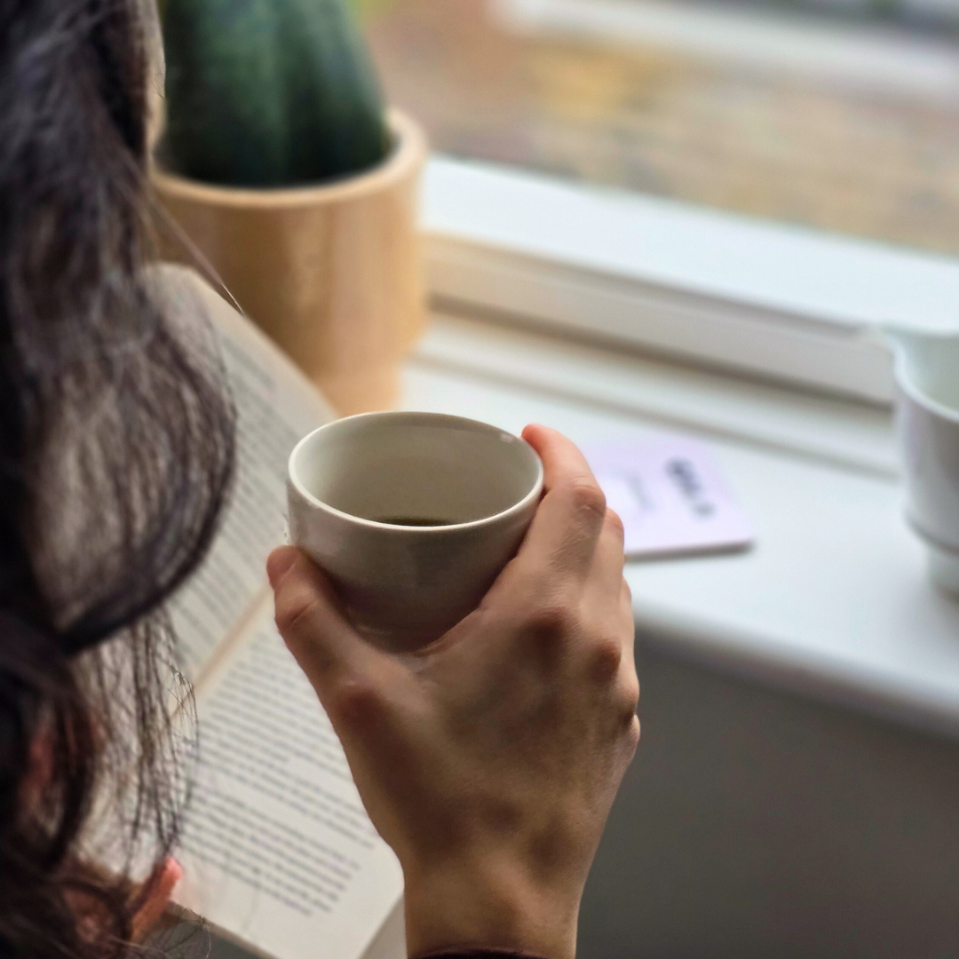 Enjoying a Calm Coffee Roastery brew with a book by the window