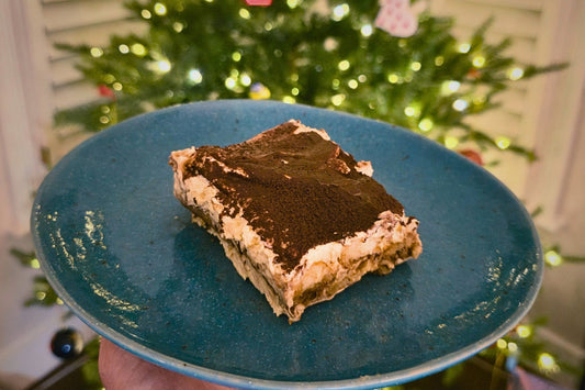 The Ultimate Decaf Tiramisu on a green plate in front of a christmas tree