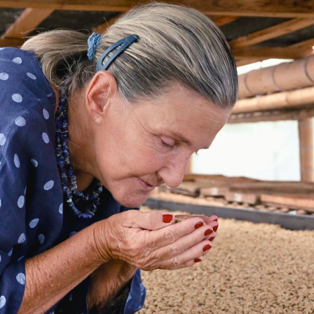 Luz Helena Salazar examining coffee beans on raised drying beds