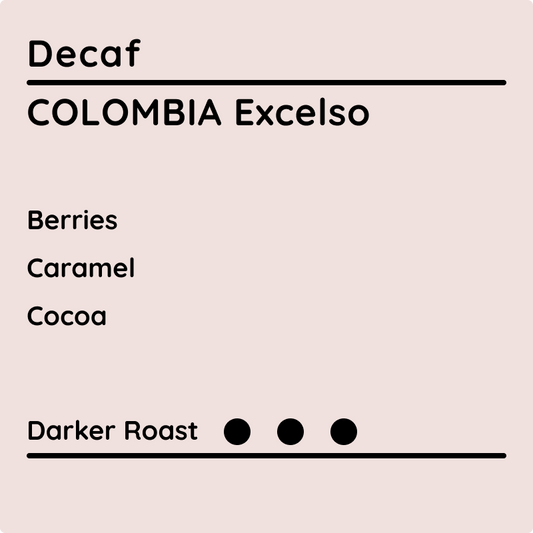 Decaf Colombia Excelso coffee label showing tasting notes of berries, caramel, and cocoa with a darker roast