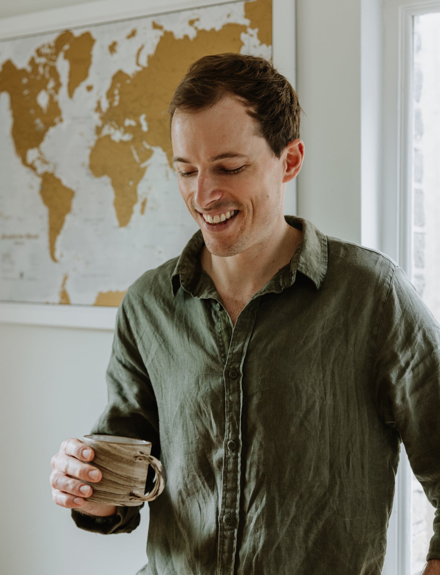 Will the founder of Calm Coffee Roastery, smiling while holding a coffee cup, enjoying a calm moment